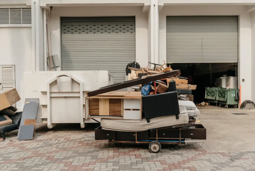 Cluttered pile of old furniture and household items waiting to be hauled away.